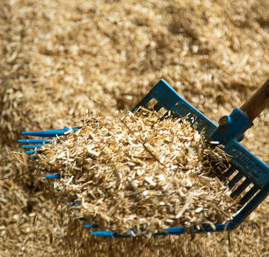 A pitchfork scooping All Walks Hemp Bedding. 